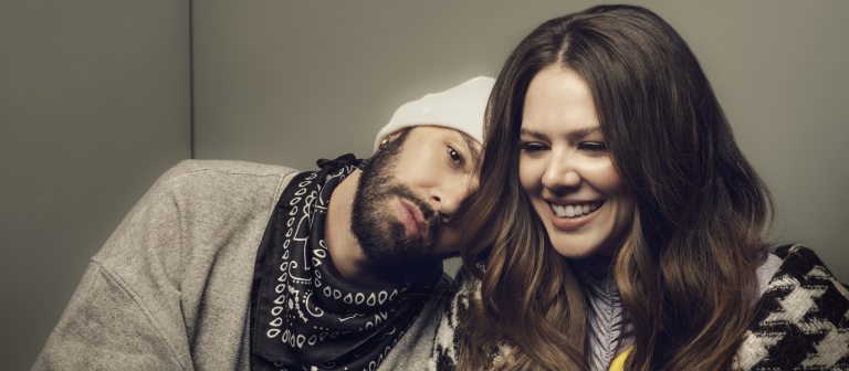 Two adults in front a wall