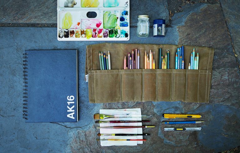 Art supplies lined up on the ground.