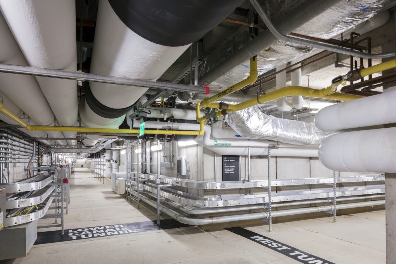 a basement-like area with white, yellow, and silver tubes and pipes