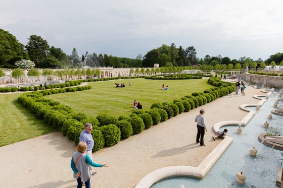 numerous people walking along the paths alongside the Main Fountain Garden at Longwood Gardens