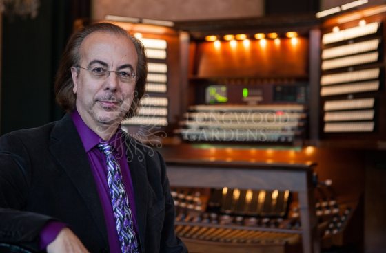 peter richard conte facing the camera sitting at an organ console