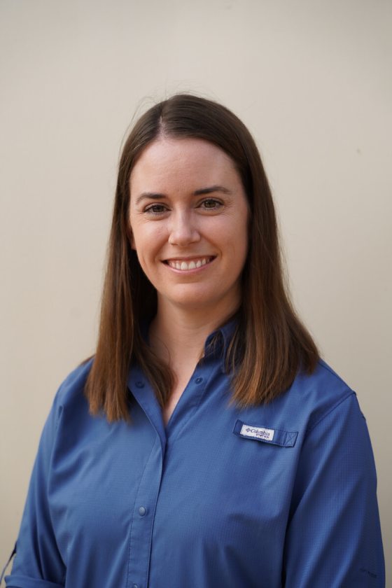 a person in a blue shirt smiling at the camera