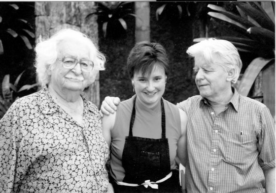 Three people with their arms around each other, posing for the camera.