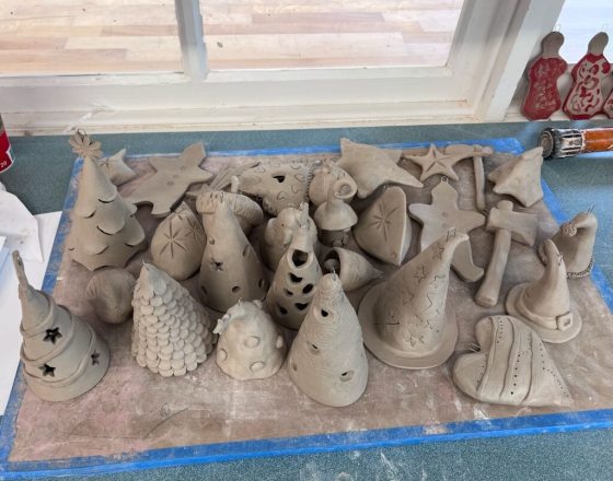 A tray of unfinished clay pieces waiting to be put into a kiln.