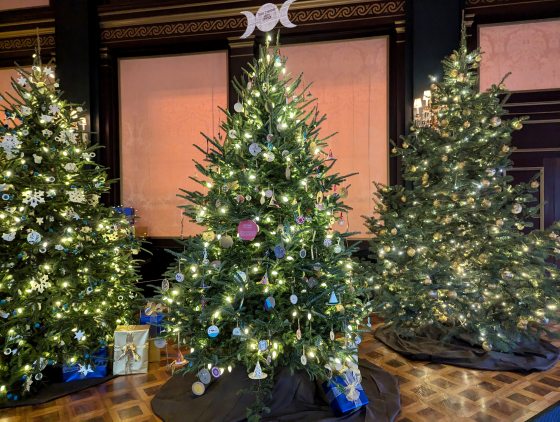 Three decorated Christmas trees inside the Ballroom at Longwood Gardens.